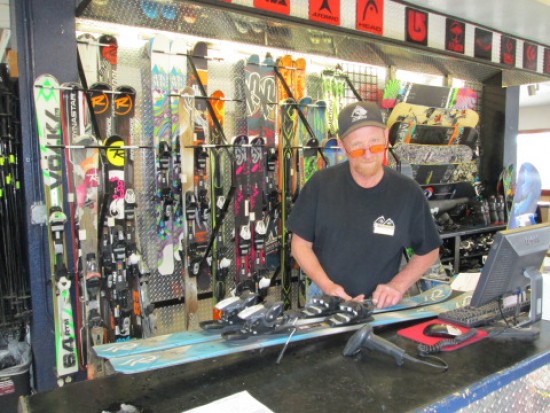 No waiting for spring skiing.  Ski rental technician John at Big Bear tunes up high performance equipment for a guest.